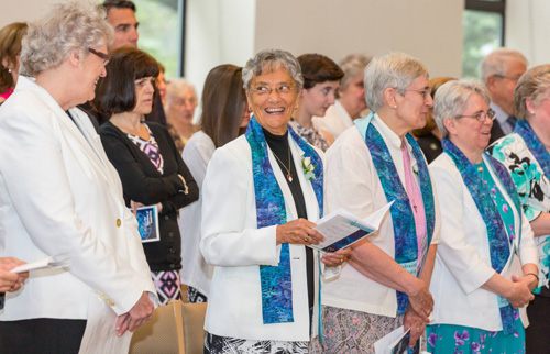 Sister Arlene Antczak, OP, former prioress (far left), and Sister Patrice Werner, OP, prioress, share a moment during the Mass of Transition. Photo by Pushparaj Aitwal.