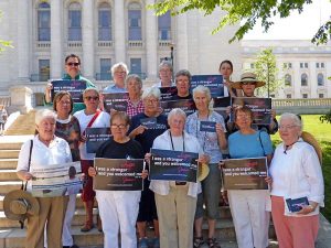 Sinsinawa Dominican Sisters Ruth Poochigian, Sheila Fitzgerald, Maureen McDonnell, Joan Duerst, Mary Ellen O’Grady, Mary Rathert, Pat Leahy, Miriam Brown, Mary Ann Nelson, and Isabel Rafferty along with Presentation Sister Joy Peterson and others gather on the capitol steps in Madison for the prayer service.