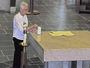 Joyce Fruge, mentor of Mary Veen, lights a candle in gratitude for Mary.