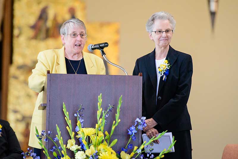 Sister Fran Nadolny, OP, Administrator and General Councilor of the Adrian Dominican Sisters, introduces Sister Catherine DeClercq, OP, Outstanding Alumni Award recipient at Siena Heights University. (Photo by Laura Marsh, of Siena Heights University)